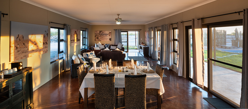 Brightly lit open-plan lounge and dining area at Safari House with large windows and modern furnishings.