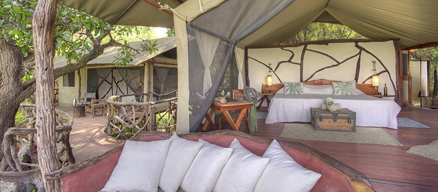 An inviting treehouse suite at Sarara with a king-sized bed, open-air seating area, and rustic timber detailing throughout.