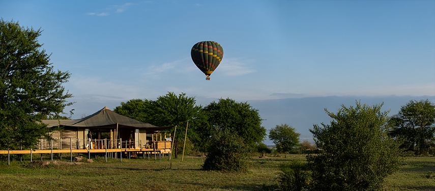 A hot-air balloon flies over Sayari tented safari camp on the Serengeti, Tanzania