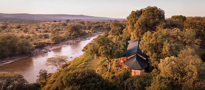 Aerial view of Serian ‘The Original’ tucked among trees beside the winding Mara River at golden hour.