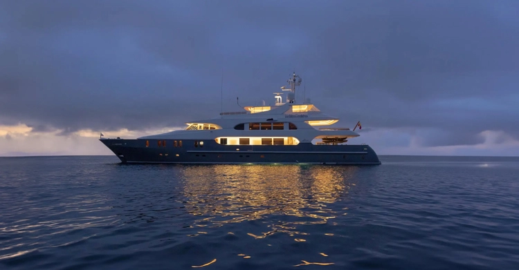 Elegant Aqua Lares yacht cutting through the Indian Ocean, leaving a white wake against a vast expanse of cobalt sea.
