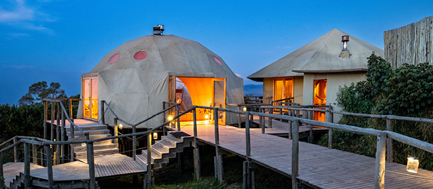 levated walkway connecting dome tents at The Highlands during twilight