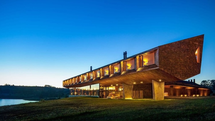 Exterior view of Refugia Lodge at twilight with dramatic, angular architecture and hillside setting