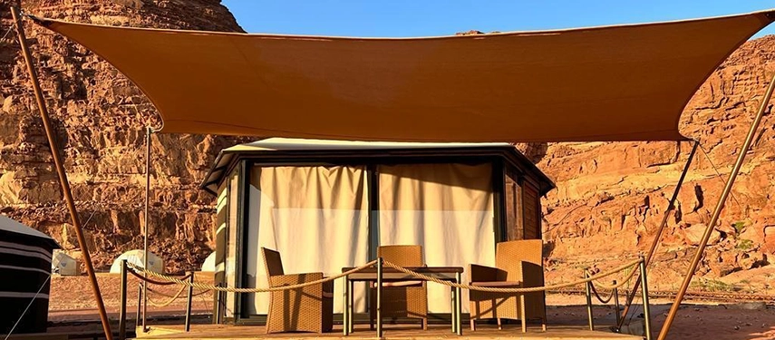 A private shaded deck outside the tent offers front row views of the dramatic sandstone landscape of Wadi Rum.