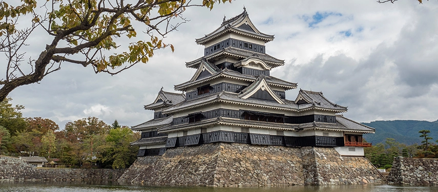 Matsumoto Castle rises beyond soft cherry blossoms, highlighting one of Japan’s most iconic original feudal fortresses.
