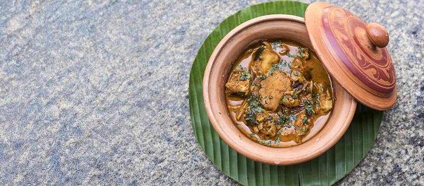 Traditional Sri Lankan curry served in a clay pot on a banana leaf.