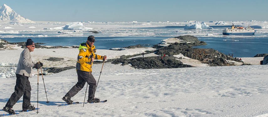 Two men snowshoeing through the Antarctic tundra