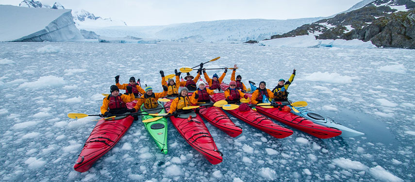 Kayakers paddling through an ice floe in Antarctica