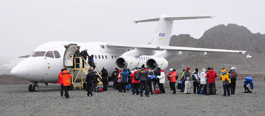 A jet plane amongst snowdrifts with passengers disembarking in Antarctica