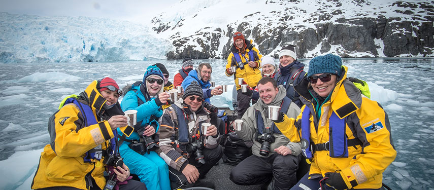 Group of tourists in a zodiac exploring the islands surrounding Antarctica