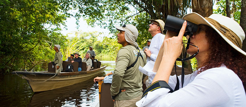 Group of tourists exploring the Amazon River and surrounding rainforest by boat