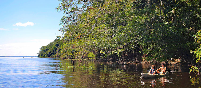 Couple kayaking on the Amazon River as part of a luxury Amazon River cruise