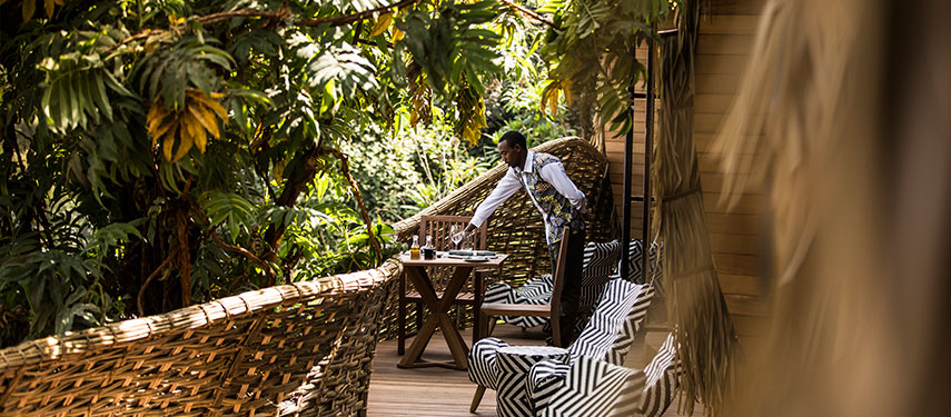 A waiter serves drinks on a private balcony at Bisate Lodge, Rwanda
