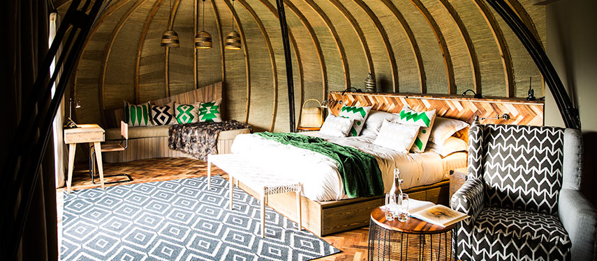 Luxurious double suite with a thatched roof looking out over Volcanoes National Park, Rwanda