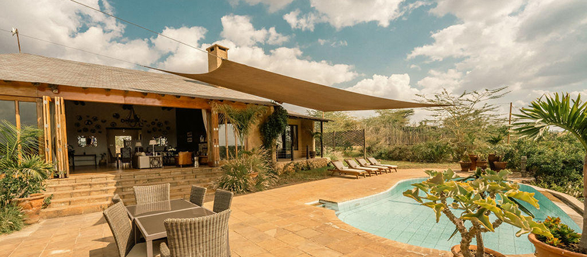 The Emakoko’s outdoor pool and terrace area under a shaded canopy, surrounded by lounge chairs and greenery.