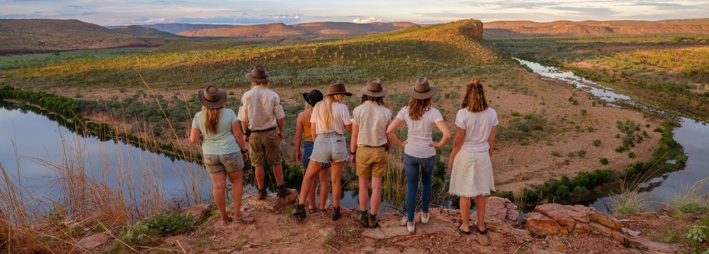 Group of hikers stand on an escarpment overlooking Chamberlain Gorge