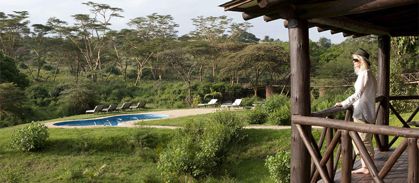 A woman gazes from her private balcony across the gardens of Emakoko and Nairobi National Park beyond.
