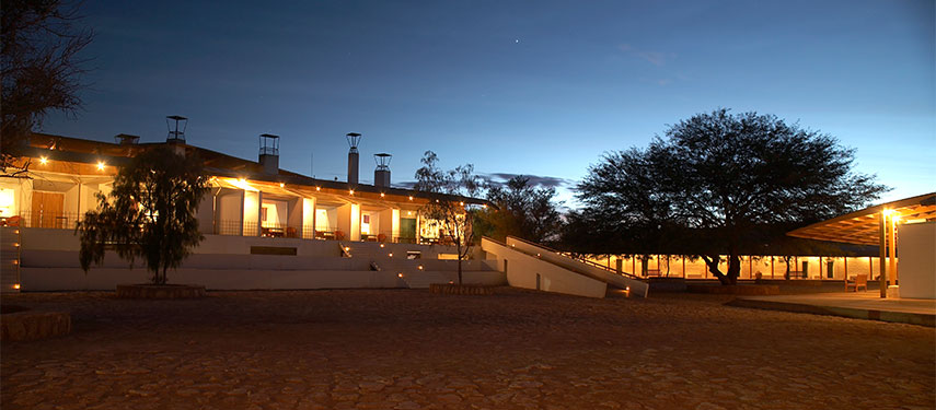 Explora Atacama hotel at sunset, illuminated by warm lighting