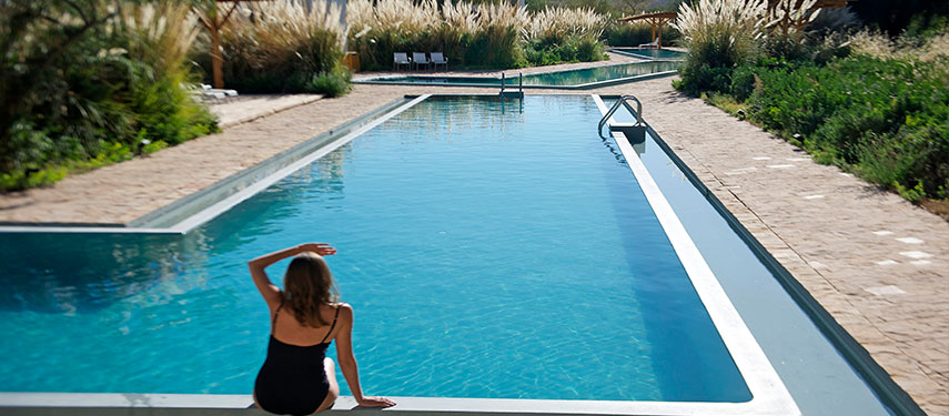 Woman by a clear, blue swimming pool at a luxury hotel in the Atacama Desert