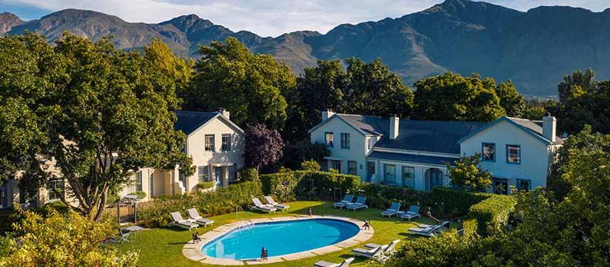Relax by the pool at Le Quartier Francais while being surrounded by beautiful lush trees and mountains