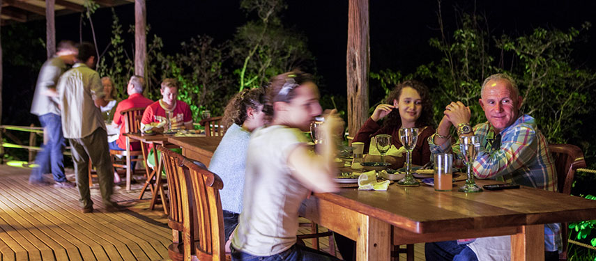 A group of tourists dine at night at Galápagos Safari Camp