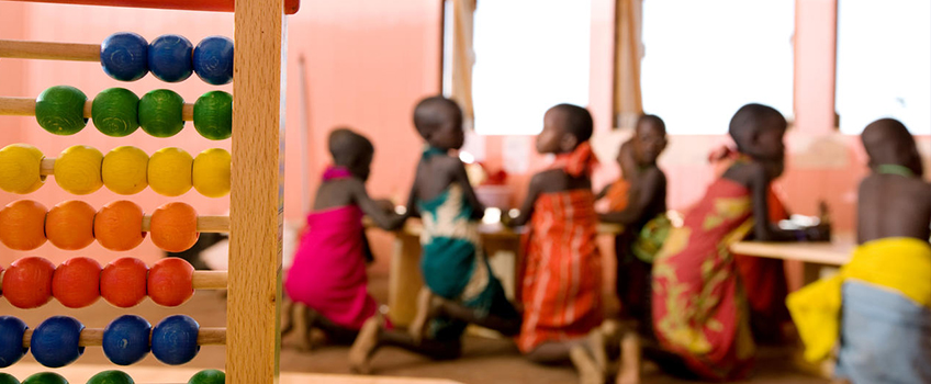 A Maasai school in Kenya, with young students playing in the background