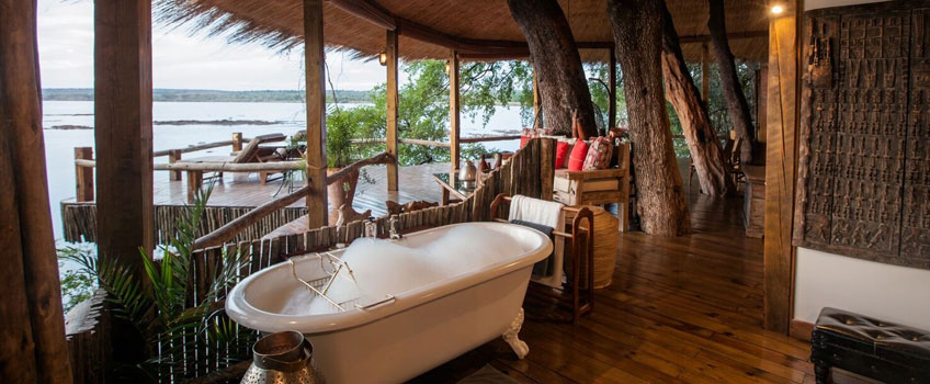 A bubble-filled claw-footed bath overlooking the Zambezi River at Tongabezi Camp, Zambia.