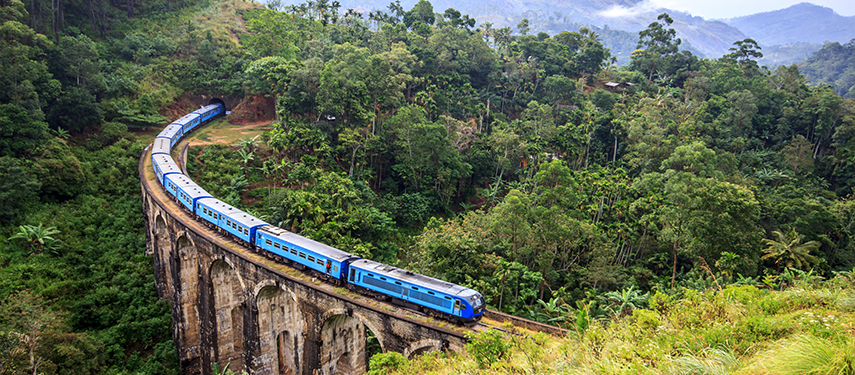 The Kandy-to-Ella Blue Train passing over a large viaduct in the hills of Sri Lanka