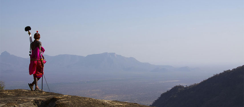 Maasai man looking out at the vast Namunyak Wilderness from Sarara Camp in Kenya
