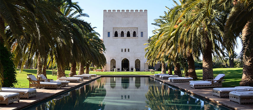 Relax by the pool under the shade of palm trees at Ksar Char Bagh in Marrakech