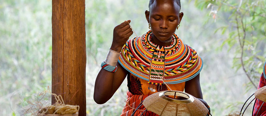 Maasai lady crafting a bearded necklace