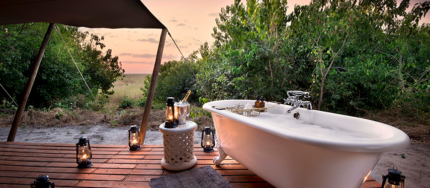 Relax in your secluded outdoor bath with views of the marshes at Linyanti Bush camp