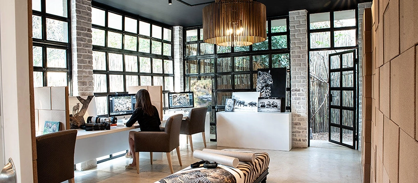 Photography studio at Londolozi with editing stations, large windows, and wildlife images on display.