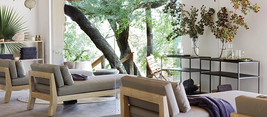 Tranquil Londolozi Healing House relaxation lounge with modern daybeds and views of surrounding trees.