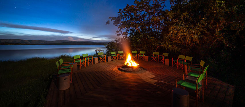 A glowing fire pit on the banks of Lake Rwanyakazinga, Rwanda at sunset