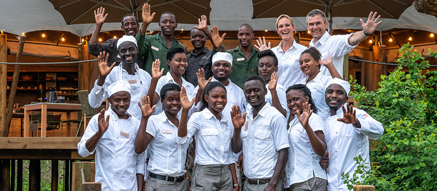 The staff of Magashi Camp, Rwanda, waving happily
