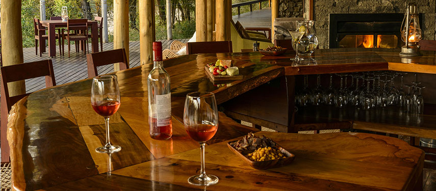 Two wine glasses sitting on a bar at a South African safari lodge