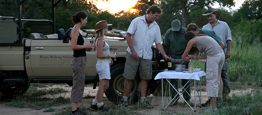Group of tourists enjoys sundowners on a private game drive in Kruger National Park