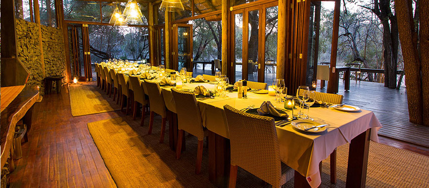 Dining aera set for dinner at sundown at a luxurious safari lodge in South Africa