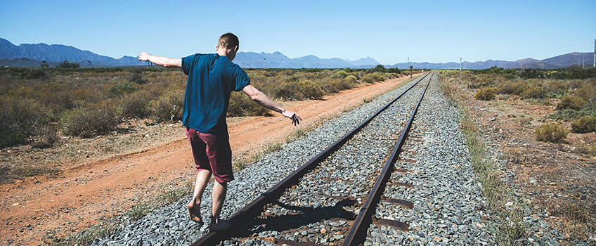 A boy balancing on rail tracks during a South African family road trip