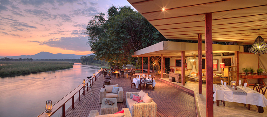 The dining deck and bar at the intimate Sausage Tree Camp, overlooking the mighty Zambezi River.