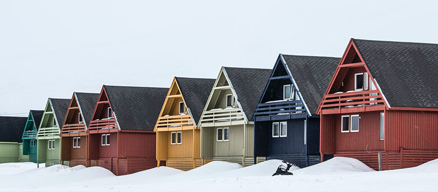 A row of colourful cabins in the snow in Norway