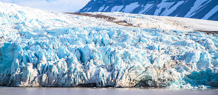 A blue glacier cascades into the Arctic seas of Norway