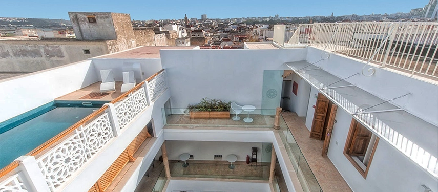 Rooftop terrace with views across Rabat’s Medina and the Atlantic coastline under a clear blue sky.
